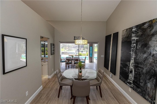 dining area featuring baseboards, a high ceiling, and wood tiled floor