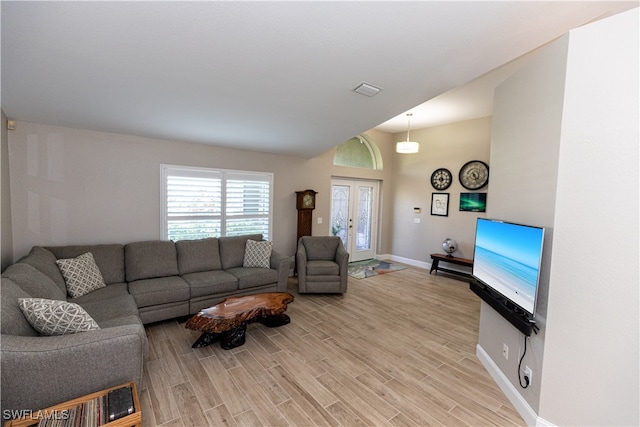 living area featuring french doors, light wood-type flooring, visible vents, and baseboards