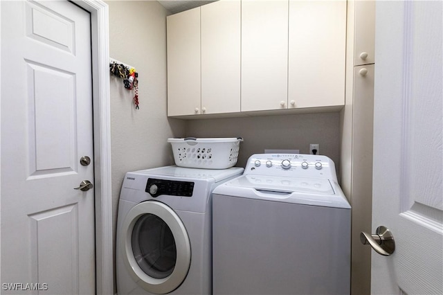 clothes washing area with cabinet space and separate washer and dryer