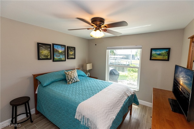 bedroom featuring a ceiling fan, baseboards, and wood finished floors