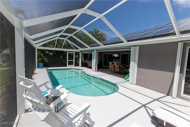 pool with glass enclosure, outdoor dining area, and a patio