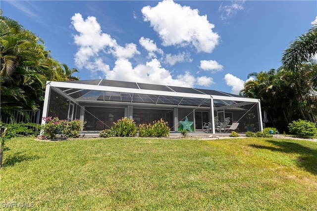 back of house with a lanai and a lawn