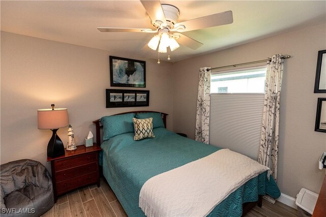 bedroom featuring a ceiling fan, baseboards, and wood finished floors