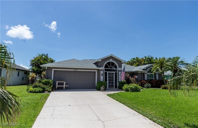 view of front of home featuring a front yard, driveway, an attached garage, and stucco siding