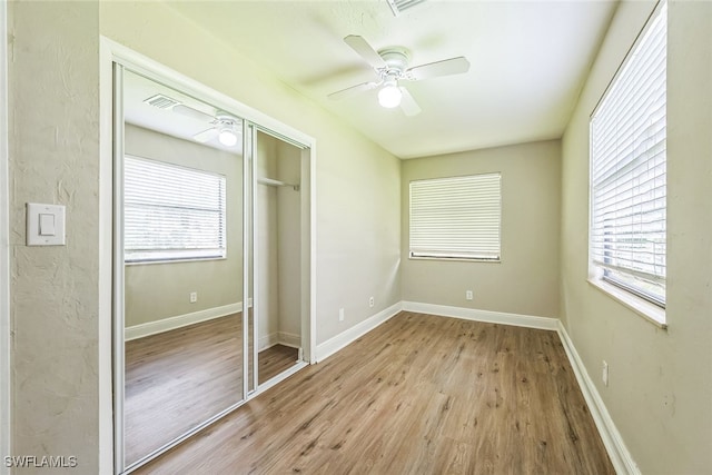 unfurnished bedroom featuring ceiling fan, a closet, and light hardwood / wood-style floors