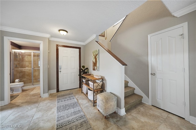 foyer entrance featuring ornamental molding and a textured ceiling