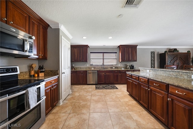 kitchen featuring sink, crown molding, dark stone counters, light tile patterned floors, and appliances with stainless steel finishes