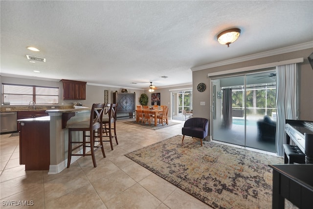 tiled living room featuring sink, a textured ceiling, and ornamental molding