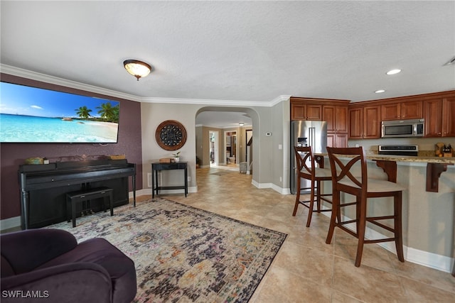 living room featuring light tile patterned floors, a textured ceiling, and ornamental molding