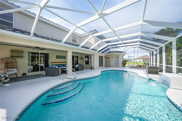 view of pool with a patio, an outdoor living space, glass enclosure, and ceiling fan