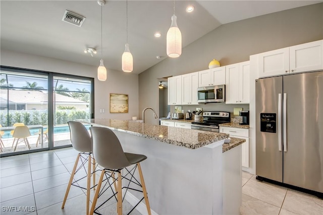 kitchen featuring light tile patterned floors, visible vents, appliances with stainless steel finishes, a kitchen breakfast bar, and white cabinetry