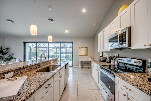 kitchen with appliances with stainless steel finishes, a sink, visible vents, and white cabinets