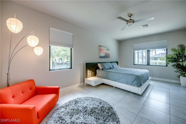 bedroom with baseboards, visible vents, ceiling fan, and tile patterned floors