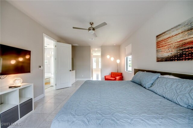 bedroom with ceiling fan, baseboards, ensuite bathroom, and light tile patterned flooring