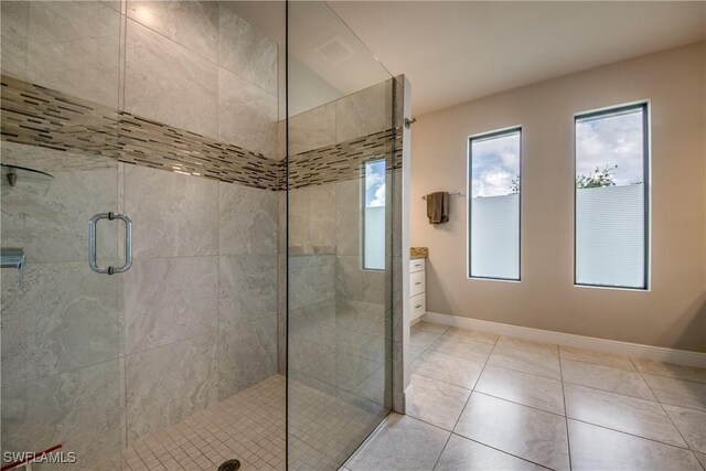 full bath with a stall shower, tile patterned floors, and baseboards