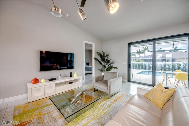 living area featuring vaulted ceiling, tile patterned flooring, and baseboards