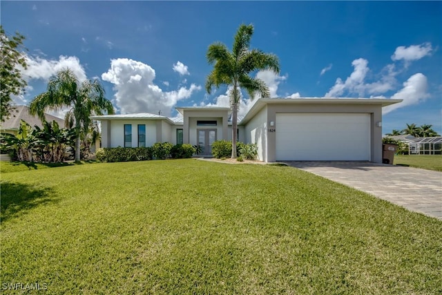 view of front of house featuring an attached garage, french doors, decorative driveway, stucco siding, and a front lawn