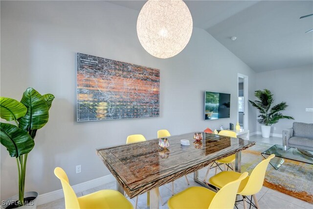 dining space with an inviting chandelier, baseboards, and vaulted ceiling