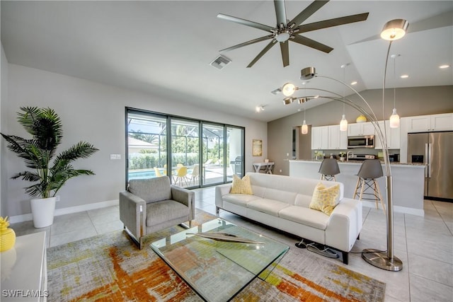 living area with light tile patterned floors, lofted ceiling, visible vents, a ceiling fan, and baseboards