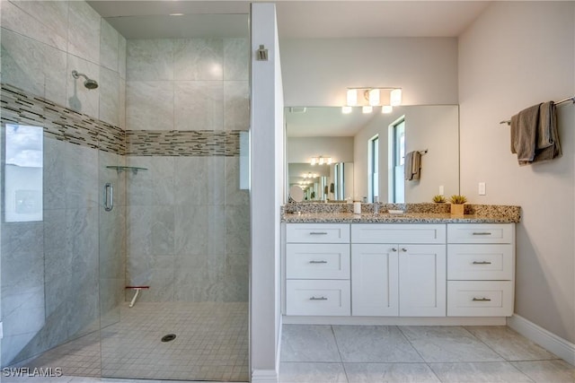 full bath featuring baseboards, tiled shower, and vanity