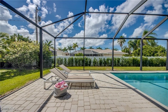 outdoor pool featuring glass enclosure, a lawn, and a patio area