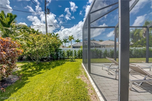 view of yard with a lanai, a patio area, and fence