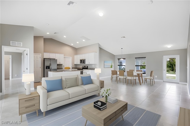 living room featuring high vaulted ceiling and light tile patterned floors