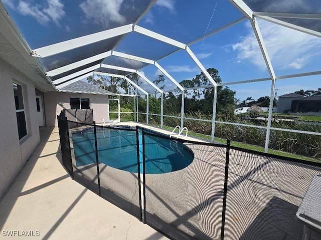 view of pool featuring glass enclosure and a patio area