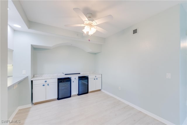 kitchen featuring light hardwood / wood-style flooring, ceiling fan, beverage cooler, and white cabinets