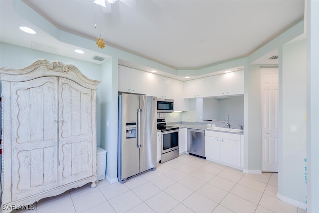 kitchen featuring appliances with stainless steel finishes, white cabinetry, and light tile patterned flooring