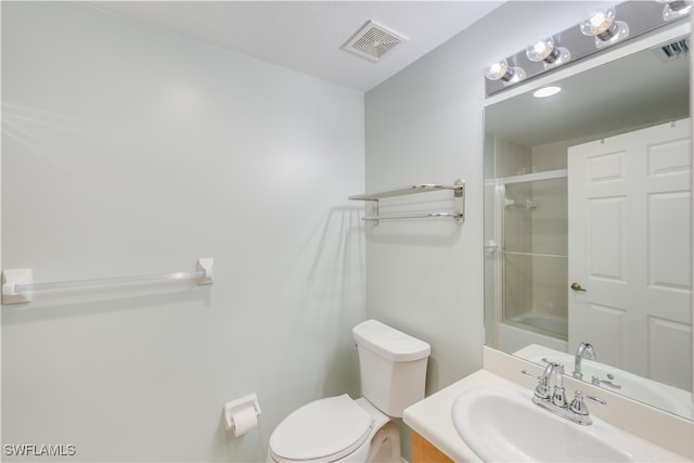 bathroom featuring a shower with shower door, toilet, and vanity