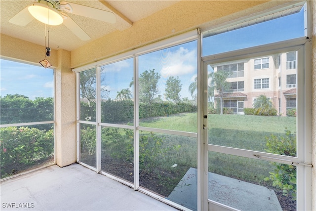 unfurnished sunroom with ceiling fan