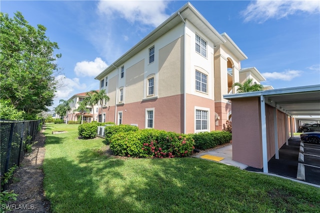 view of side of property with central AC unit, a lawn, and a carport