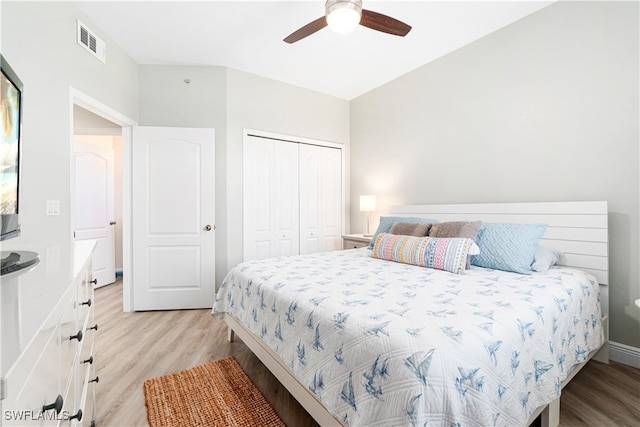 bedroom with light hardwood / wood-style flooring, ceiling fan, and a closet