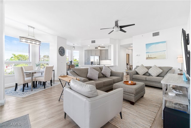 living room with light wood-type flooring and ceiling fan