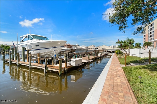 view of dock with a water view and a lawn