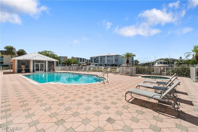 view of pool with a patio and a hot tub