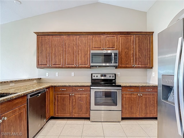 kitchen featuring lofted ceiling, appliances with stainless steel finishes, light stone counters, and light tile patterned flooring