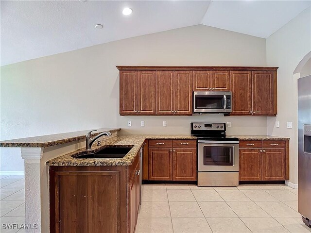 kitchen featuring light tile patterned floors, stainless steel appliances, sink, lofted ceiling, and kitchen peninsula