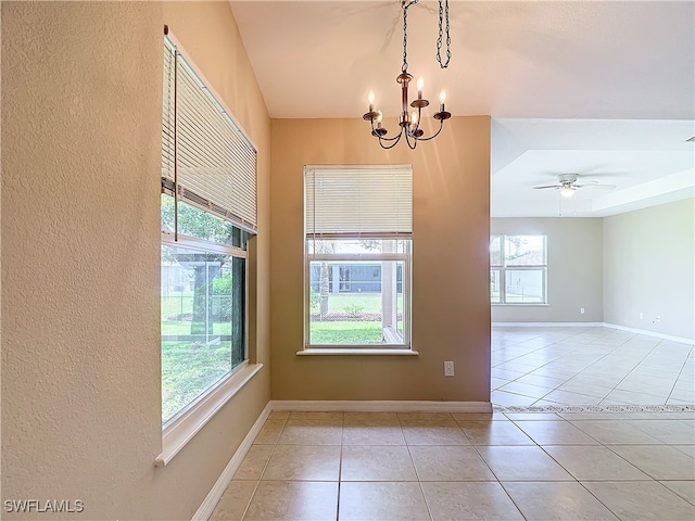 unfurnished room featuring light tile patterned floors, a healthy amount of sunlight, and ceiling fan with notable chandelier