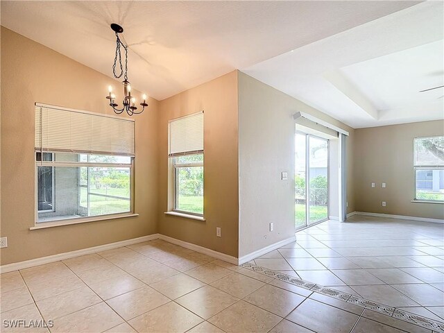 empty room featuring light tile patterned floors, plenty of natural light, and a notable chandelier