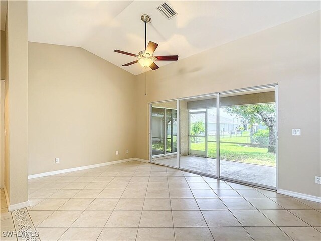 tiled empty room with vaulted ceiling, a wealth of natural light, and ceiling fan