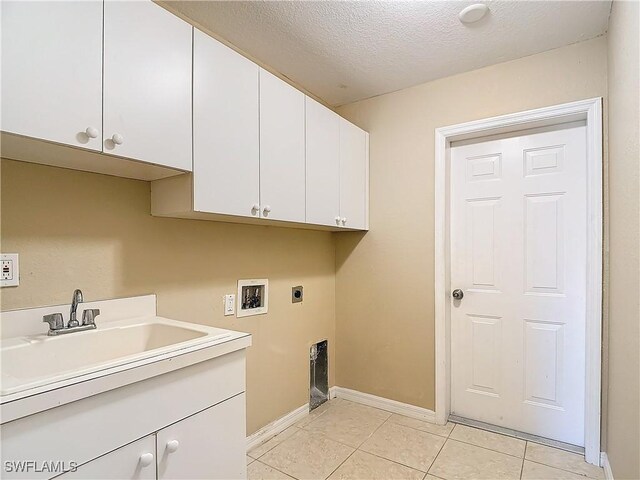 laundry area featuring a textured ceiling, hookup for a washing machine, cabinets, sink, and hookup for an electric dryer