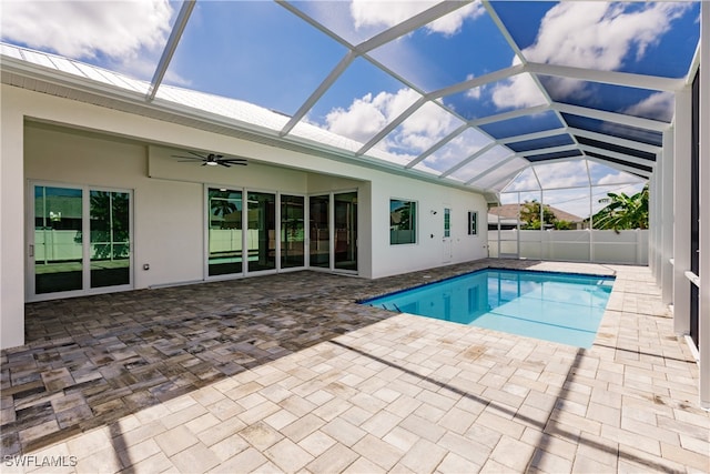 view of pool with ceiling fan, a patio area, and glass enclosure