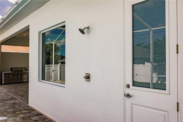 property entrance featuring a patio and stucco siding