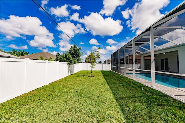 view of yard featuring a fenced in pool and glass enclosure