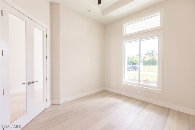 spare room featuring a wealth of natural light, light hardwood / wood-style floors, and french doors