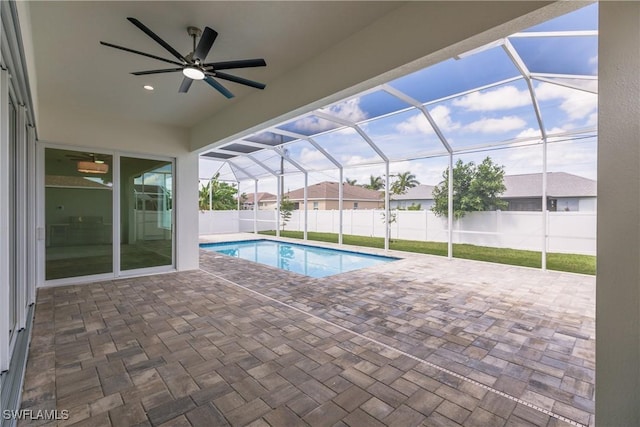 view of swimming pool with a lanai, a fenced backyard, a ceiling fan, and a patio