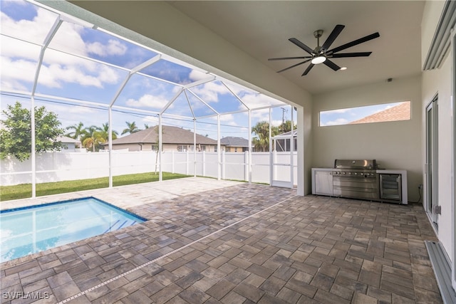 view of swimming pool featuring exterior kitchen, ceiling fan, a patio, and glass enclosure