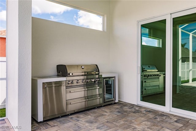 view of patio / terrace featuring wine cooler, grilling area, and an outdoor kitchen